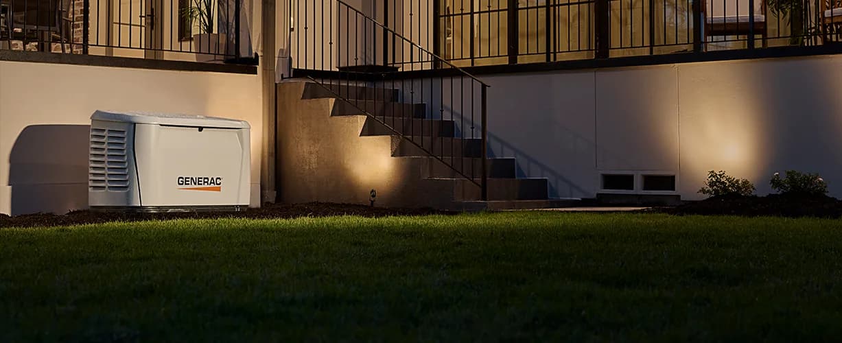 Generac Next Gen Guardian standby generator installed beside a house at dusk